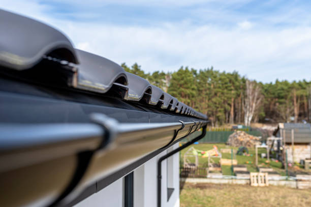 istock A metal, black gutter on a roof covered with ceramic tiles in the background a forest, view from above. 1385509444