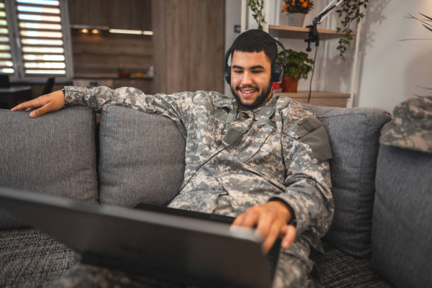 soldat utilisant un ordinateur portable à la maison - hotel occupation photos et images de collection