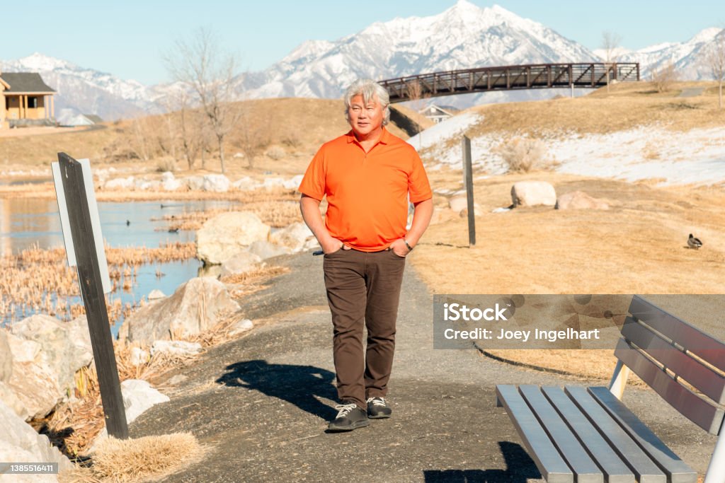 Elderly Korean Man Content with the Scenery that Surrounds Him An elderly Korean American Taking a break in the park on a Spring Day as the weather gets warmer. Asian and Indian Ethnicities Stock Photo