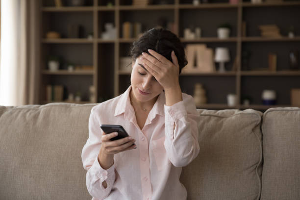 Unhappy young Hispanic woman dissatisfied with bad device work. Unhappy young Hispanic woman looking at cellphone screen, feeling confused reading message with bad news, considering problem solution, dissatisfied with lost data, broken device, wrong app work. low photos stock pictures, royalty-free photos & images