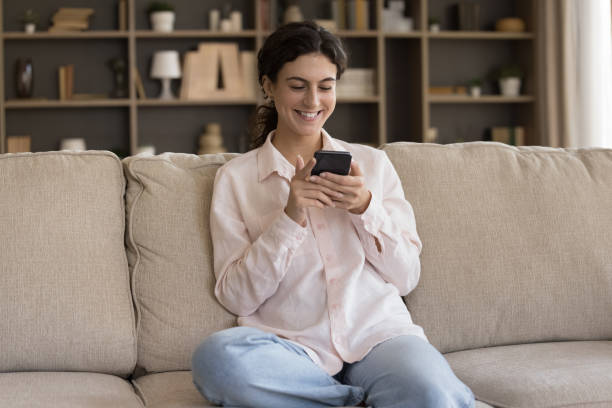 istock Smiling beautiful young Hispanic woman using smartphone. 1385517961