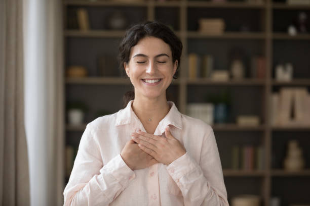 istock Grateful happy young Hispanic woman folded hands on chest. 1385518011