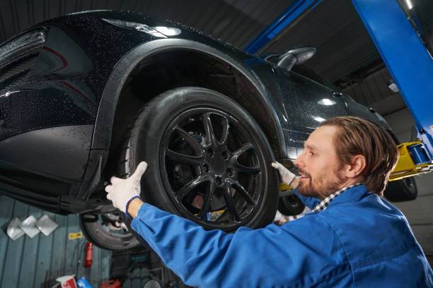 istock Man holding car wheel and making diagnosis 1385518055