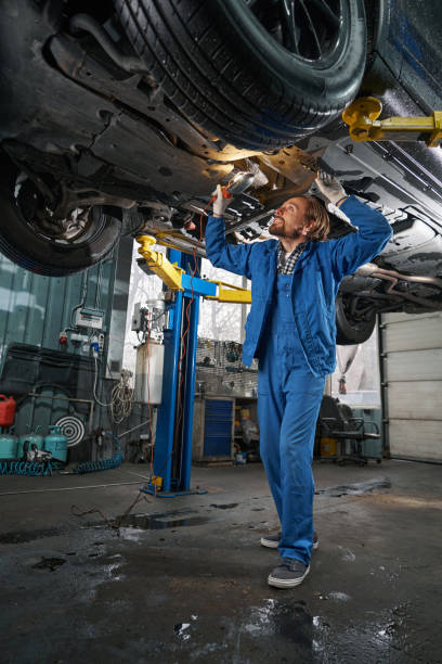 istock Mechanic holding lamp and performing machine diagnostics 1385518059
