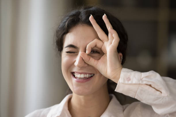 istock Close up happy young Hispanic woman making binocular sign. 1385519905