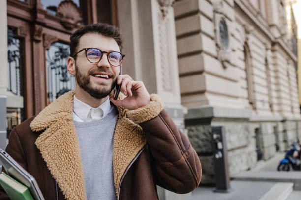 istock Young man talking on the phone on the street 1385519929