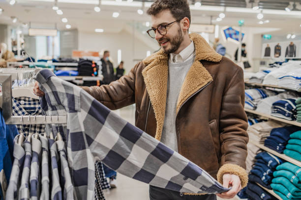 istock Young man buys clothes in a store 1385520049