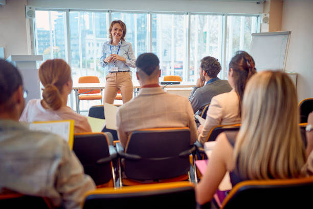 donna d'affari senior che tiene la presentazione - corso di formazione foto e immagini stock