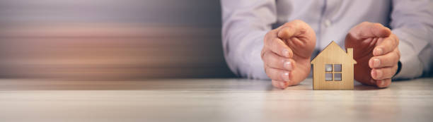 istock Business man hand hold the house model 1385520534