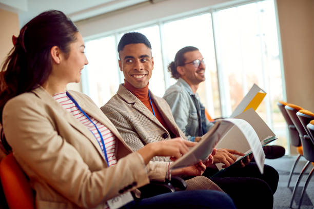 istock Young participants are talking about writings during a business lecture in the conference room. Business, people, company 1385521085