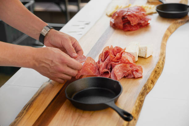 chef che prepara una tagliera di salumi - delicatessen meat cold cuts chopped foto e immagini stock