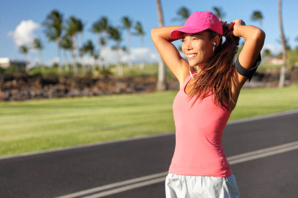 Active Asian runner woman tying hair into ponytail getting ready to run her morning jogging workout. Happy healthy lifestyle. Fitness wellness life Active Asian runner woman tying hair into ponytail getting ready to run her morning jogging workout. Happy healthy lifestyle. Fitness wellness life. woman tying hair in ponytail getting ready for exercising stock pictures, royalty-free photos & images