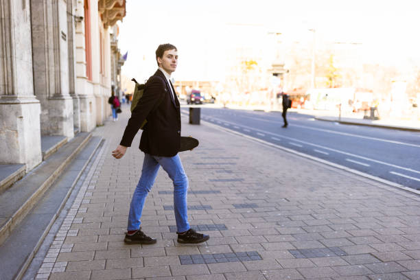 istock Young man with skateboard leaving building 1385521872
