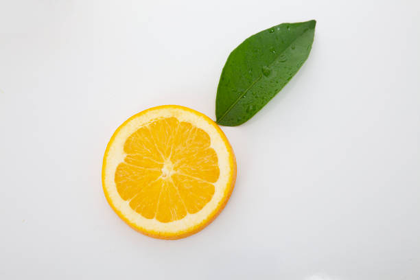 Half slice of orange fruit with green leaves