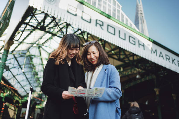 Mother and daughter time Asian mother and daughter find their next destination from the map at Borough Market, London borough market stock pictures, royalty-free photos & images