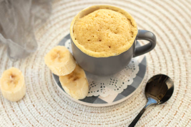 istock cupcake in a mug with banana pieces. Banana cupcake on a light background. 1385527478