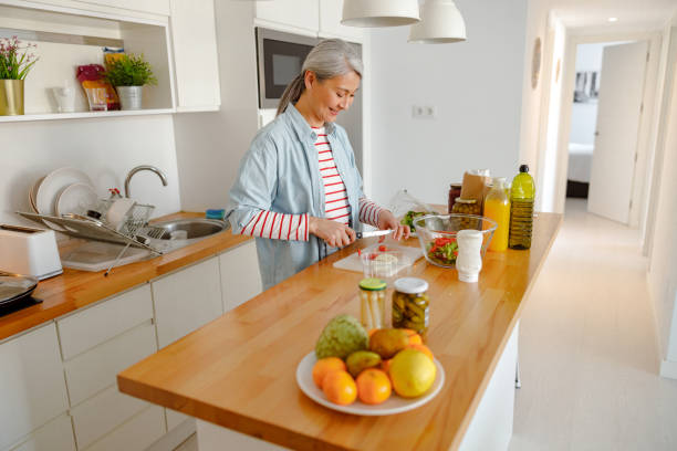 istock Smiling woman preparing ingredients for salad in kitchen 1385527875