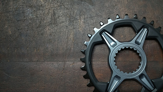 photo - bike chainwheel - bicycle parts close up on a dark wood background
