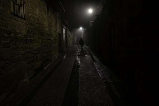 Woman in dark street walking, creepy person,fear