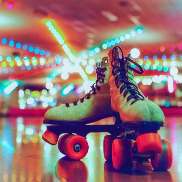 Retro Roller Skates on a Roller Skating Rink A pair of retro roller skates on a roller skating rink. roller rink stock pictures, royalty-free photos & images