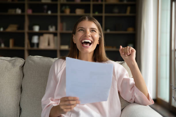 istock Happy young beautiful woman using cellphone, resting on sofa. 1385530400