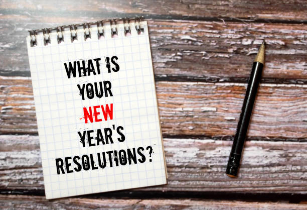 istock Top View Of Office Desk and Notepad With Text - What is Your New Year's Resolutions 1385532839