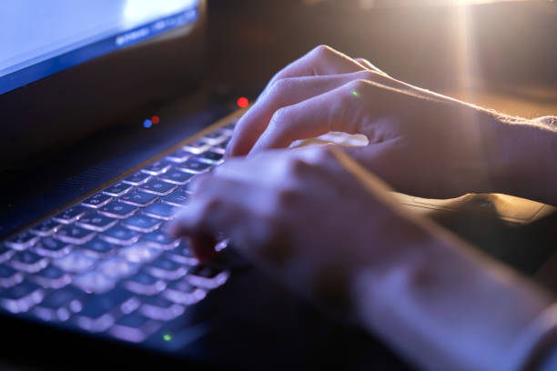istock Girl is working on a laptop at night, hands closeup. 1385534093
