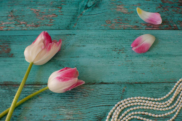 A soft focus photograph of pink and white tulips and freshwater pearls.