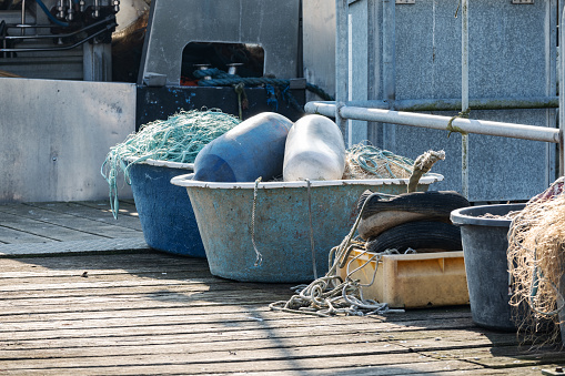 Fishing nets and fenders in old vats on the jetty in the port of Travemunde, Lubeck, on the Baltic Sea, copy space, selected focus