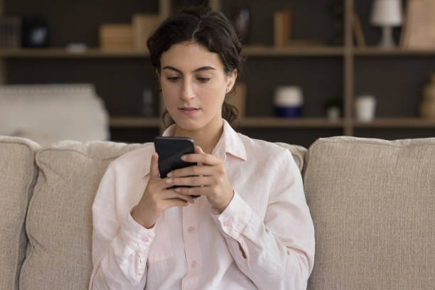 istock Addicted to modern tech concentrated young Hispanic woman using cellphone. 1385537927