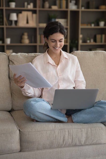 istock Vertical image joyful young Hispanic woman involved in paperwork 1385537931