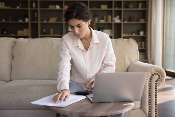 istock Focused millennial Hispanic woman doing domestic paperwork. 1385537936