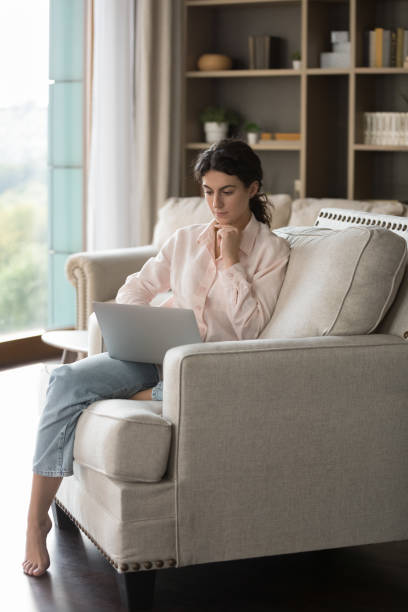 istock Concentrated young Hispanic woman using computer at home. 1385537957