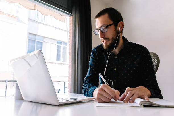 istock Man working at home and writing down his plan of action 1385538923
