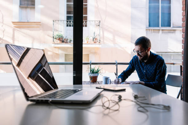 istock Man working at home and writing down his plan of action 1385538946