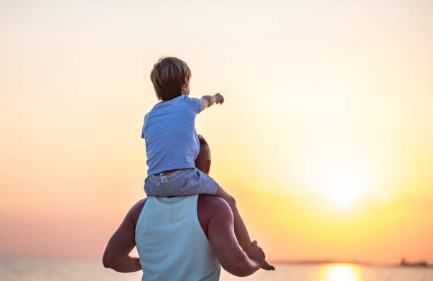 istock Rear view father and son at the beach 1385539523