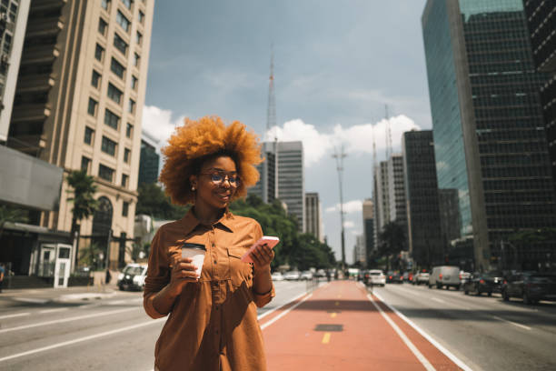mujer afro usando smartphone en avenida paulista - cafe laptop espresso business fotografías e imágenes de stock