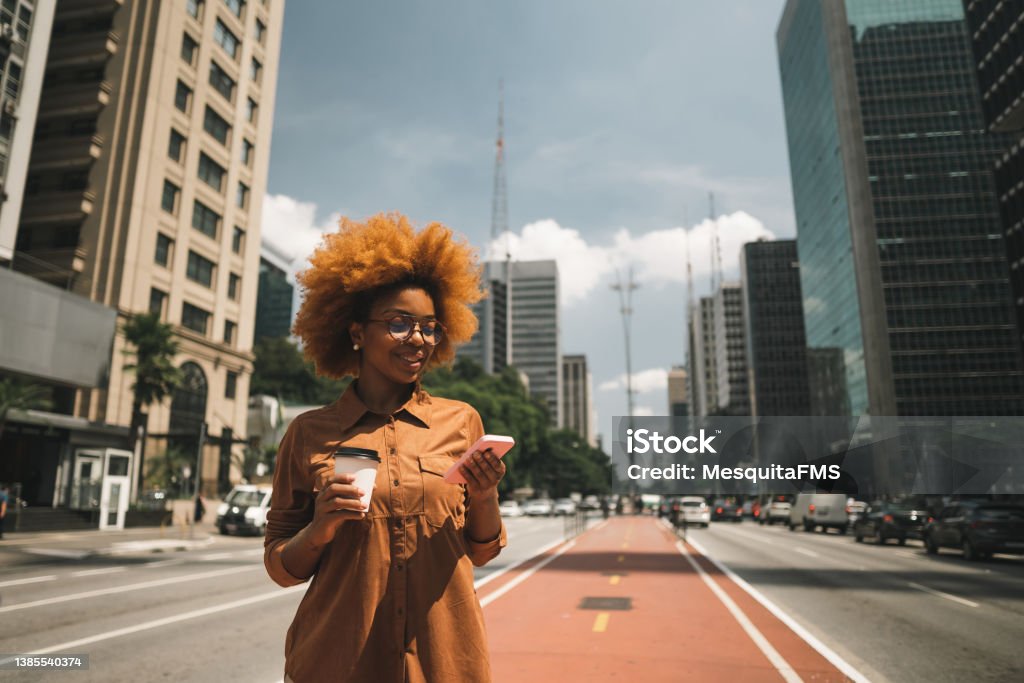 Afro woman using smartphone on Avenida Paulista Businesswoman on Avenida Paulista in Sao Paulo, Brazil São Paulo Stock Photo