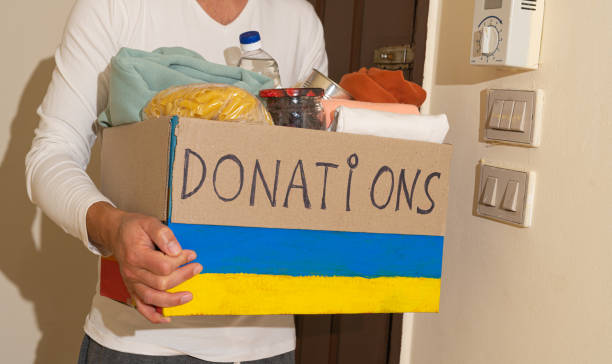 Close up of man cyrrying box with Humanitarian aid for Ukrainian refugees stock photo