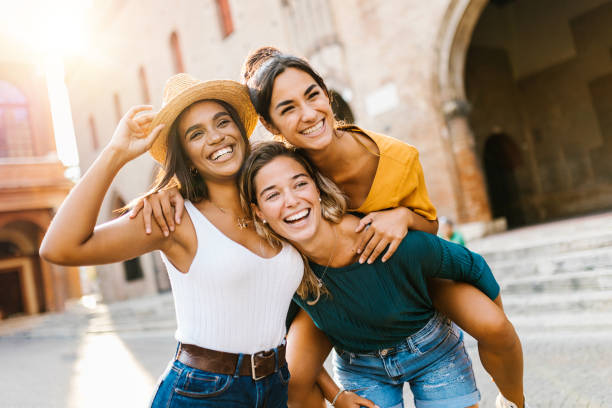 grupo multiétnico de tres jóvenes felices divirtiéndose en las vacaciones de verano - group of people women cheerful friendship fotografías e imágenes de stock