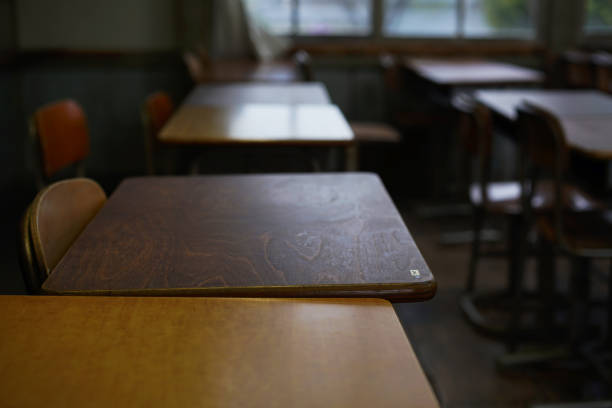 istock Desks and chairs lined up in an old elementary school classroom 1385563808