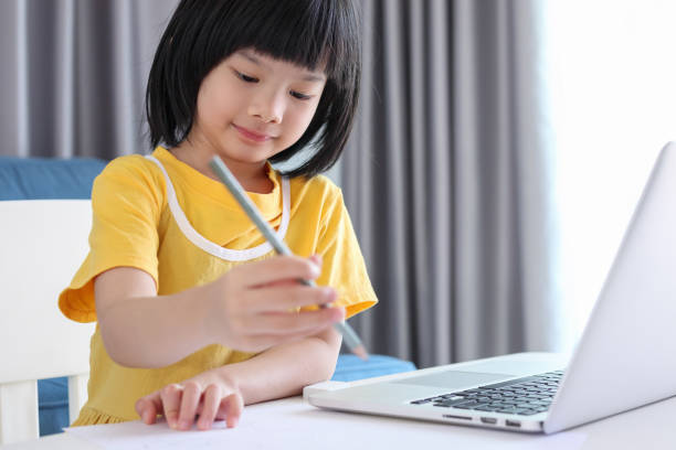 istock little asian girl student study online using laptop computer at home 1385568310
