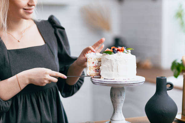 istock Pastry chef confectioner young caucasian woman with cake on kitchen table. 1385568930