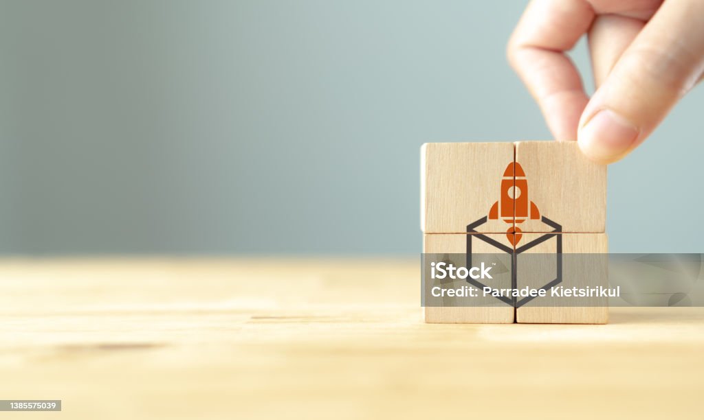 Concept of new business project startup development and launch a new innovation product on a market.
Think outside the box. Creative ideas.
Hand put wooden cubes with rocket launching out of the box. Most Valuable Player Stock Photo