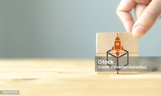 Concept Of New Business Project Startup Development And Launch A New Innovation Product On A Market Think Outside The Box Creative Ideas Hand Put Wooden Cubes With Rocket Launching Out Of The Box Stock Photo - Download Image Now