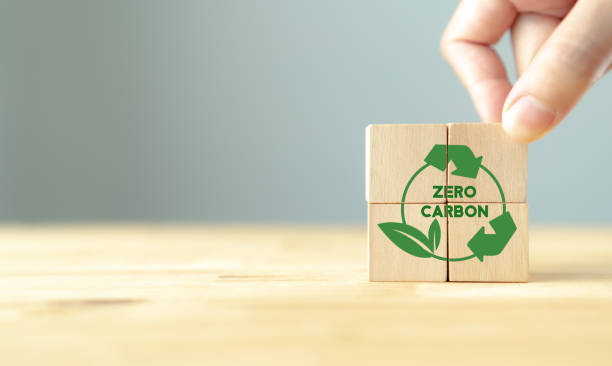 istock Zero carbon and net zero emissions concept. Carbon neutral. Climate neutral long term strategy. Sustainable business development. Hand puts wooden cube with green zero carbon icons on grey background. 1385575058