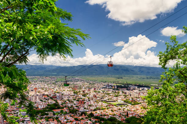 Two cable car cars cross each other on the San Bernardo hill with the capital of the northern province in the background stock photo