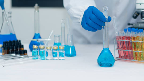 istock Scientist's hand tool holding a bottle with laboratory glassware in the background of a chemistry lab. Research and development concepts in science laboratories Medicine and Biotechnology 1385591671