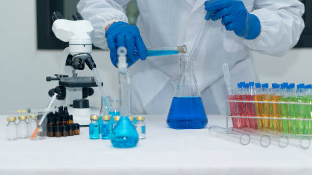 istock Scientist's hand tool holding a bottle with laboratory glassware in the background of a chemistry lab. Research and development concepts in science laboratories Medicine and Biotechnology 1385591683