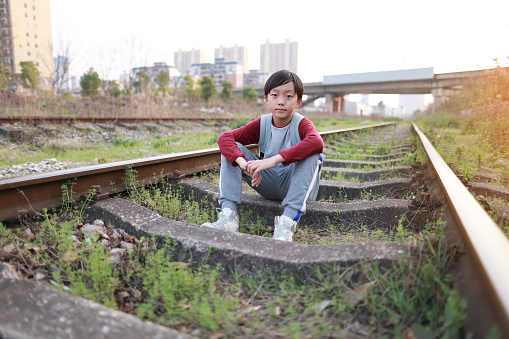 Asia boy walking on a railroad